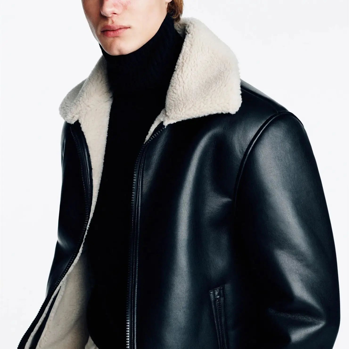 Black leather jacket with white fur collar worn by a person on a white background